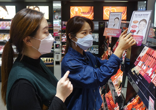 올리브영 직원이 고객에게 색조 테스터 종이 사용을 안내하고 있다.    CJ올리브영 제공